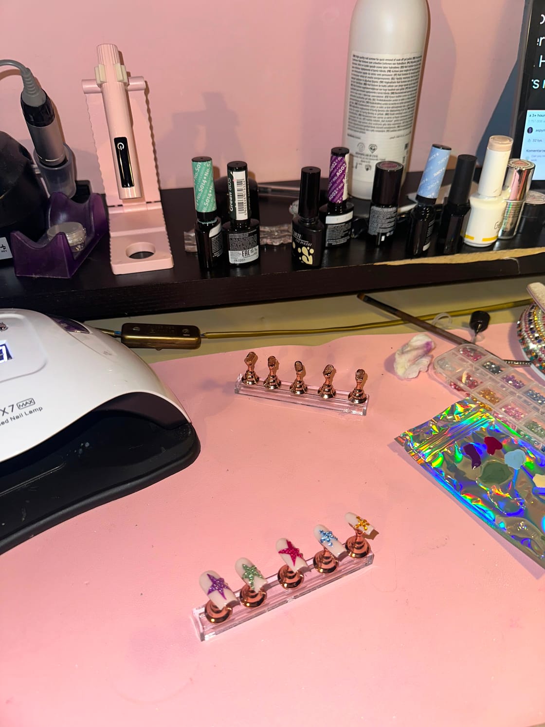 The studio desk: UV lamp, polishes and tips on their stands
