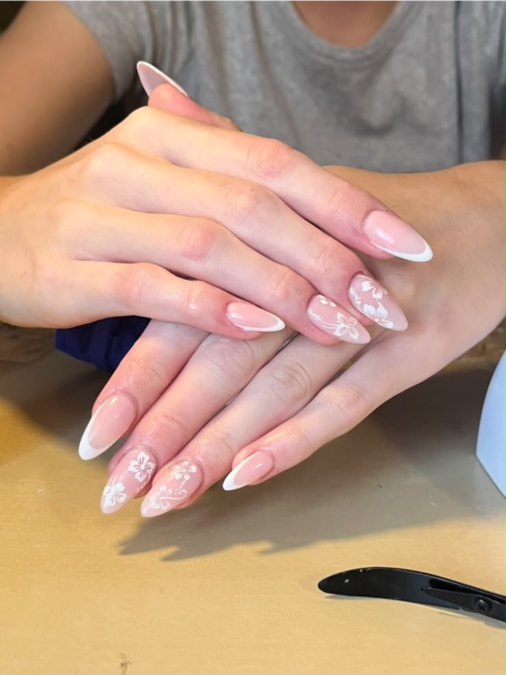 Two hands in a classic white French with hand-painted white flowers